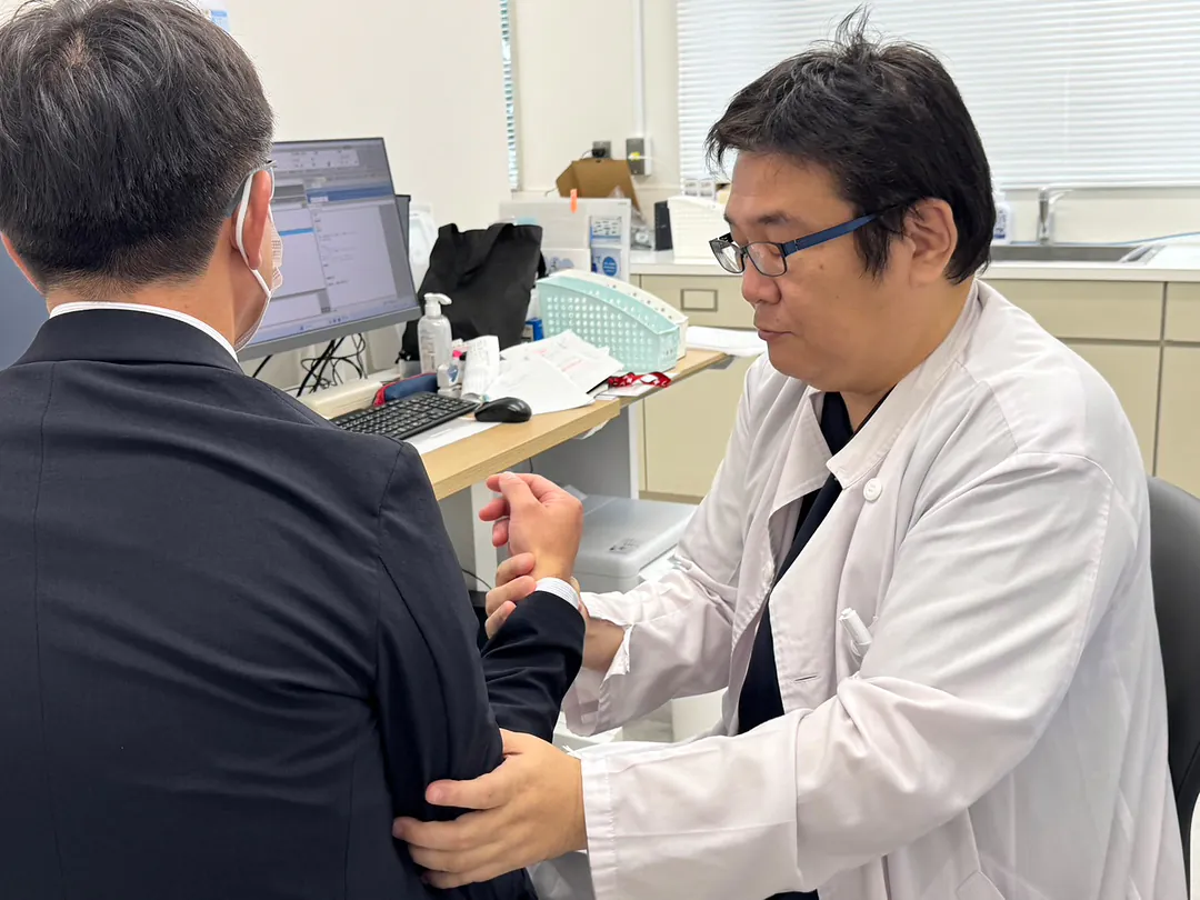 腕と手首を診察する院長